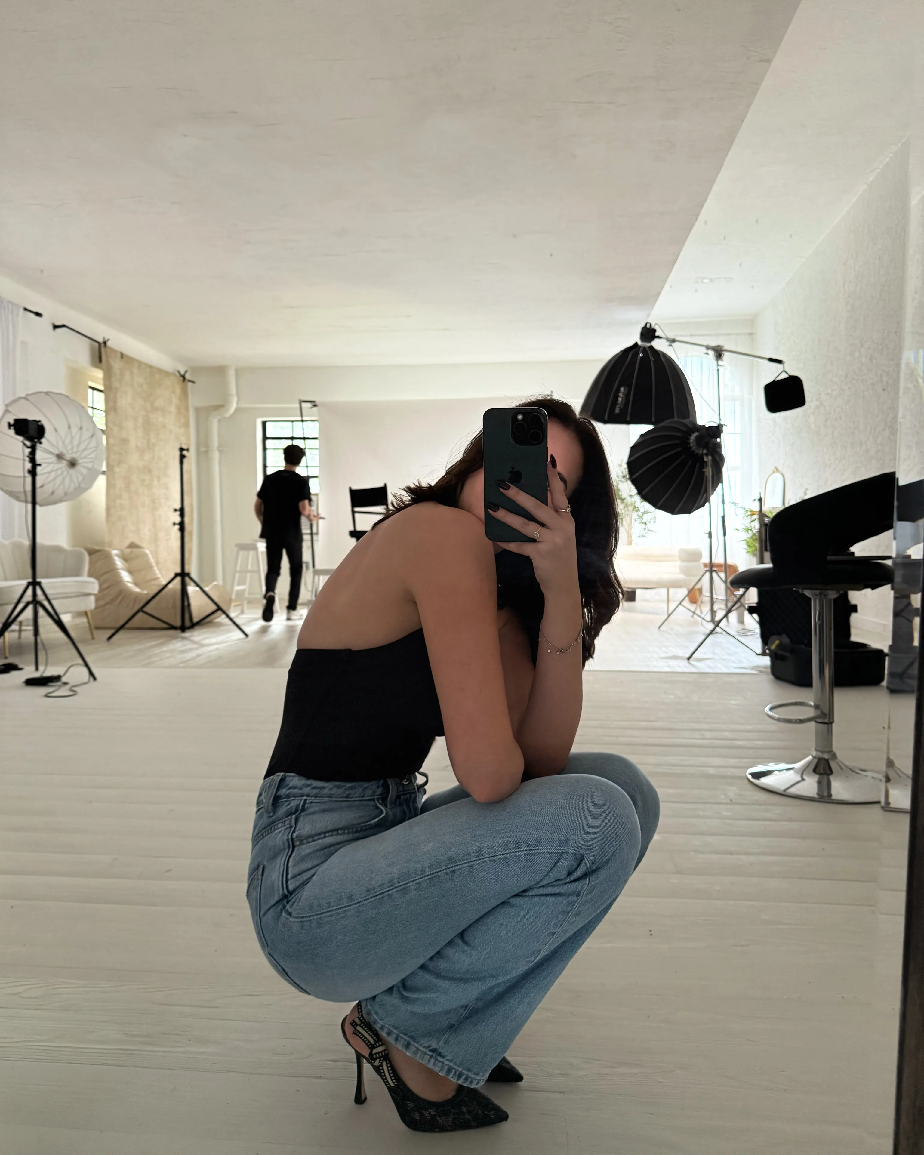 Liz taking a mirror selfie during a Blank studio shoot.