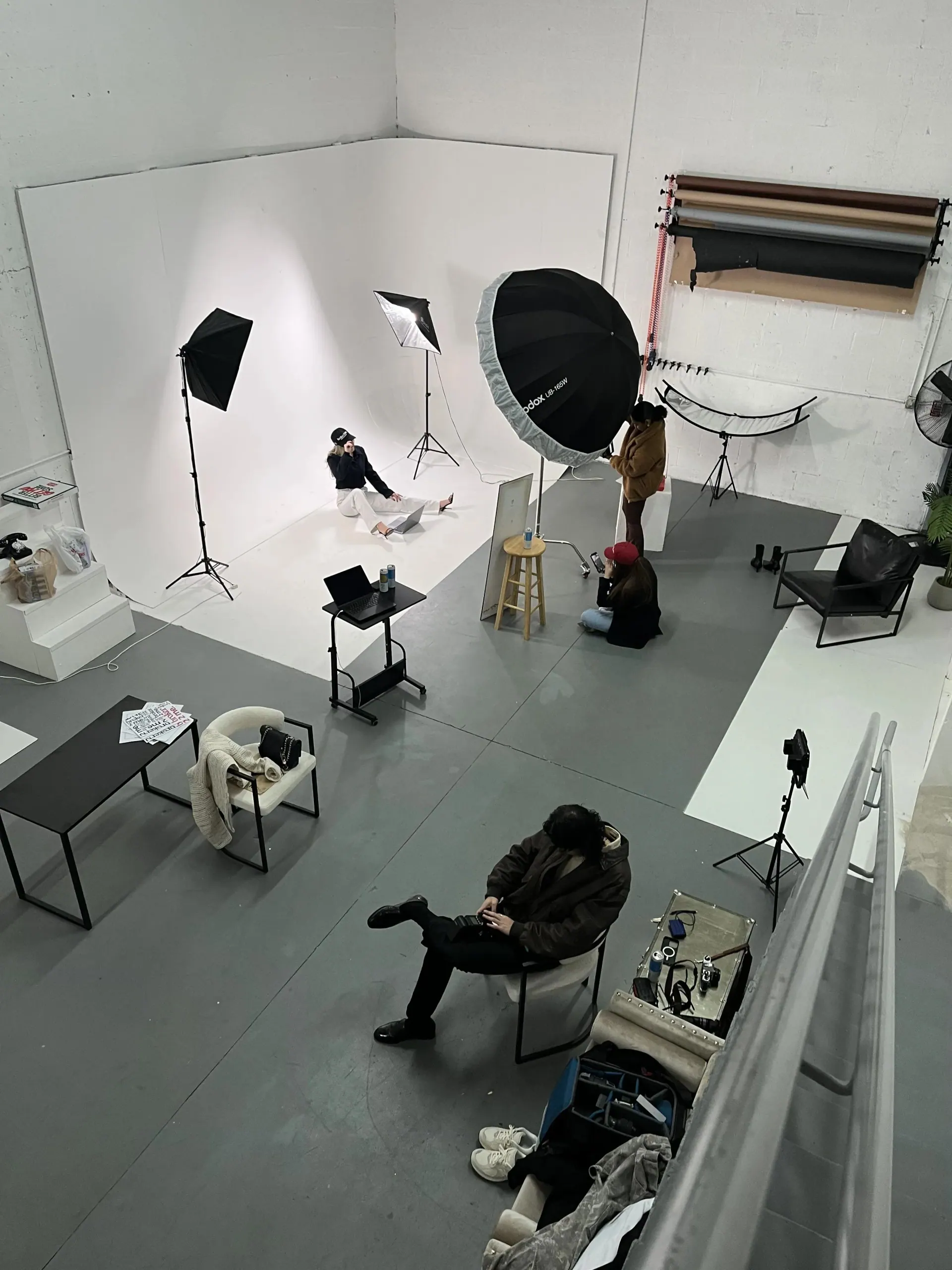 Overhead view of a Blank Marketing Group studio session — white cyclorama, softboxes, and crew between frames.