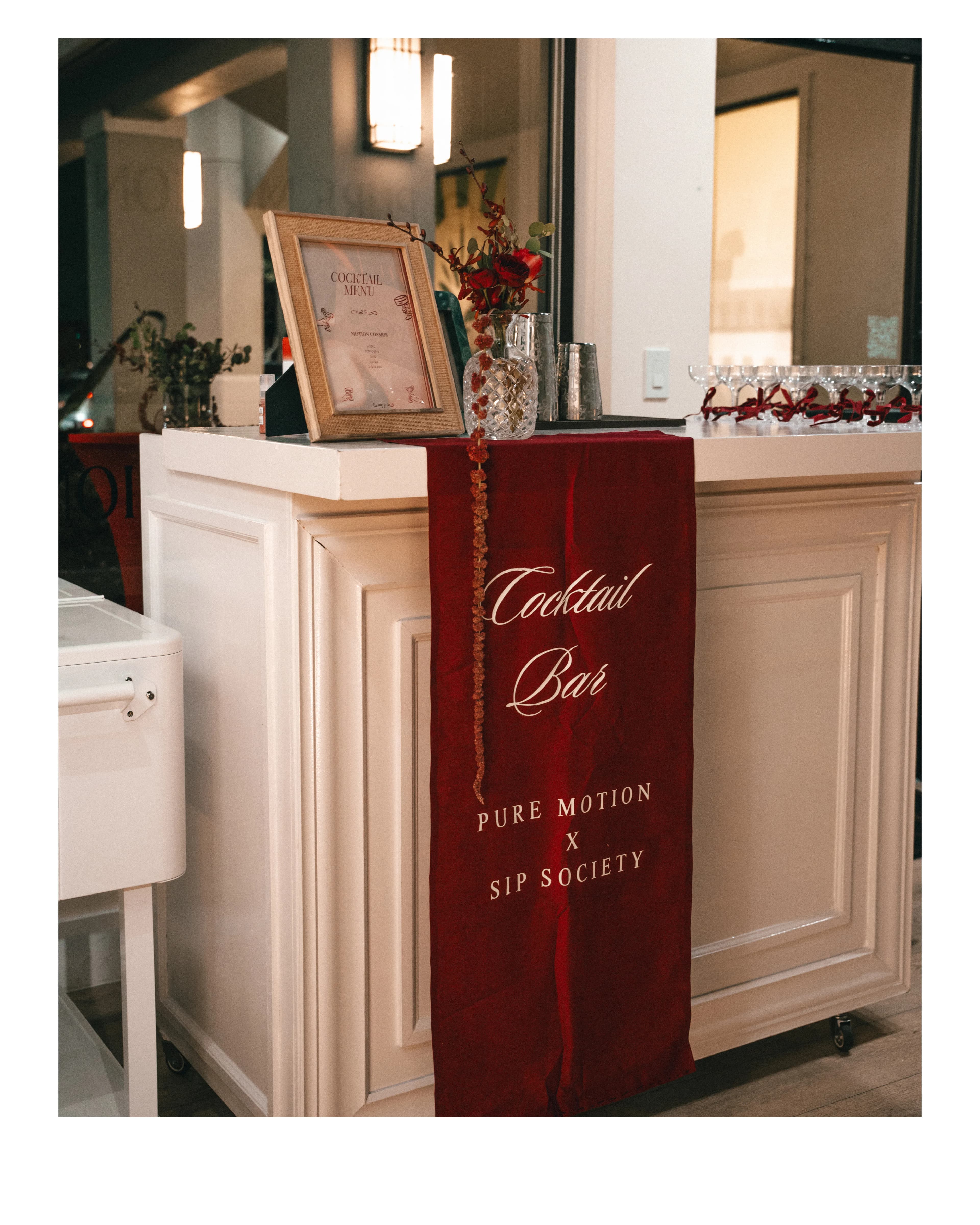 A 'Pure Motion & Sip Society' cocktail bar set up on a counter at the studio.