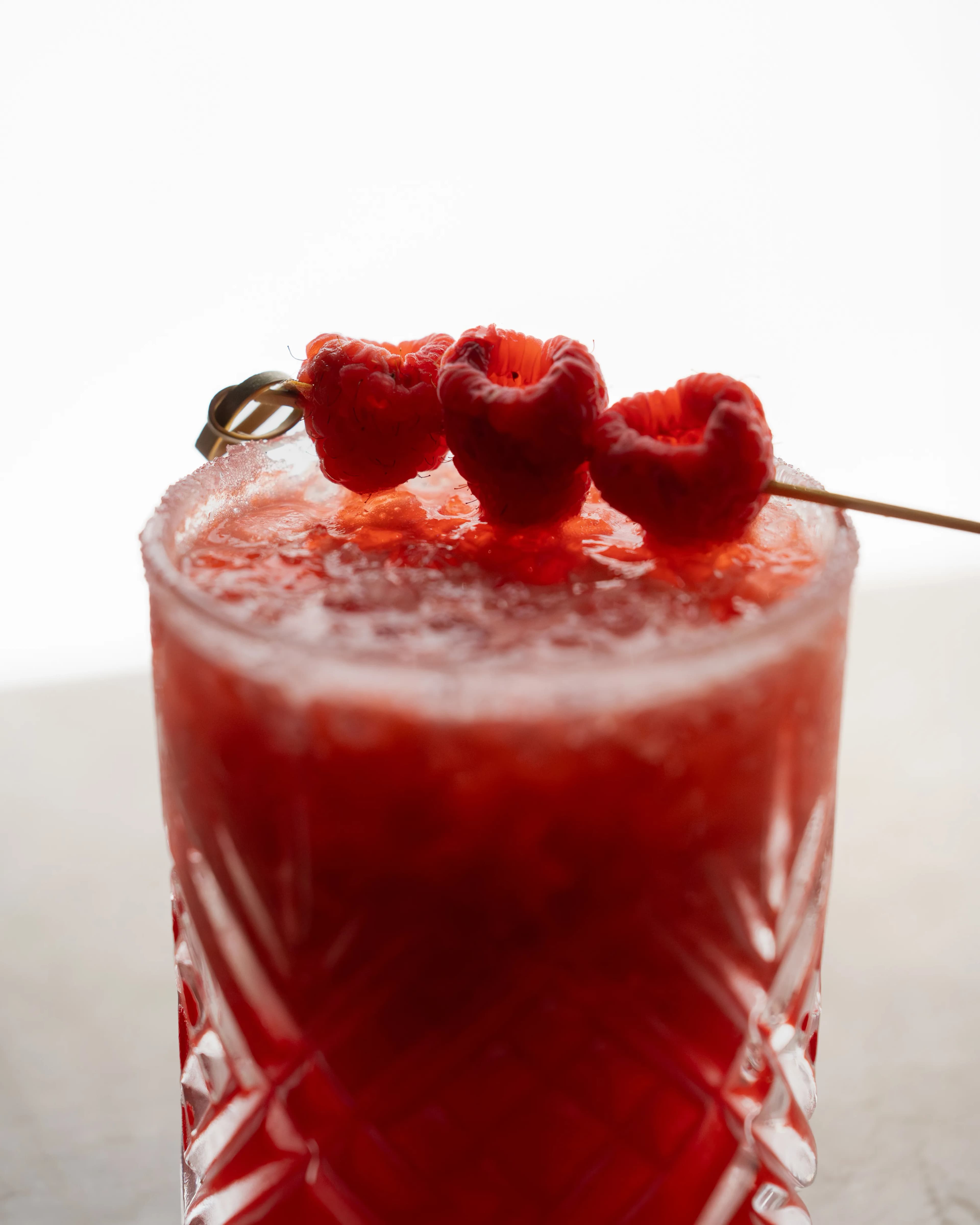 A frozen raspberry cocktail garnished with a skewer of berries at Sushi Sake.