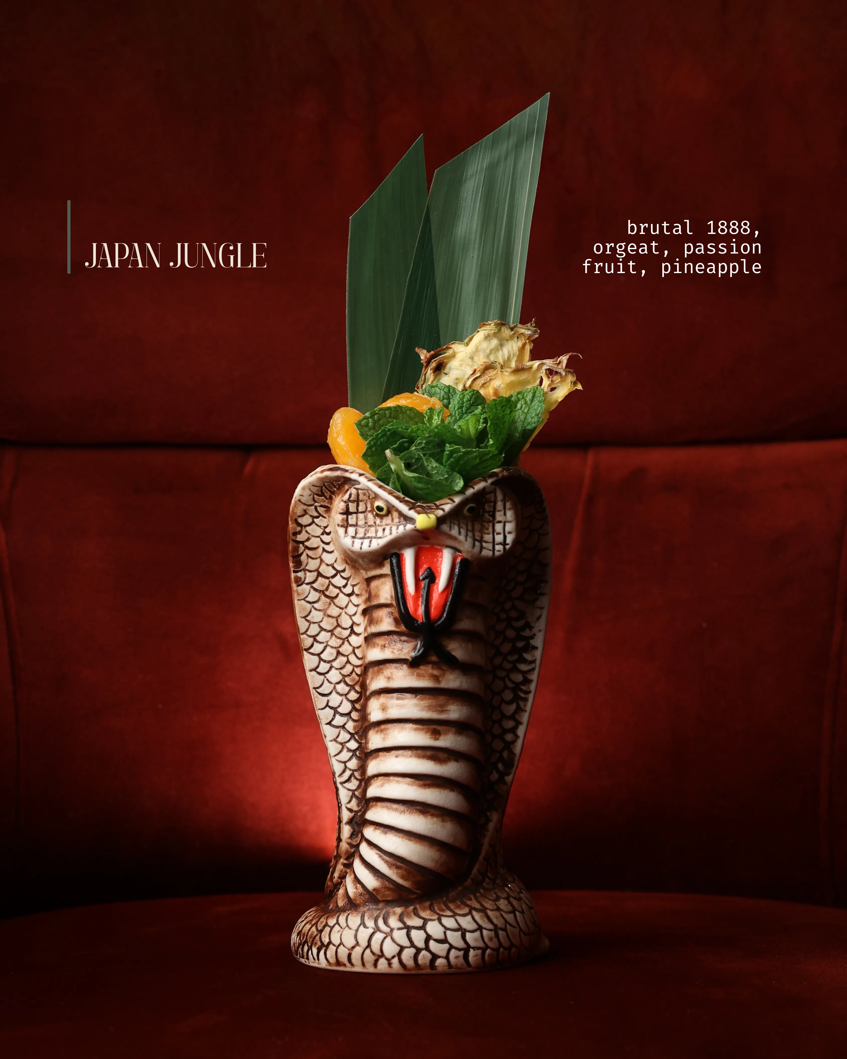 The 'Japan Jungle' cocktail served in a cobra-shaped tiki mug against deep red velvet at Sushi Sake.