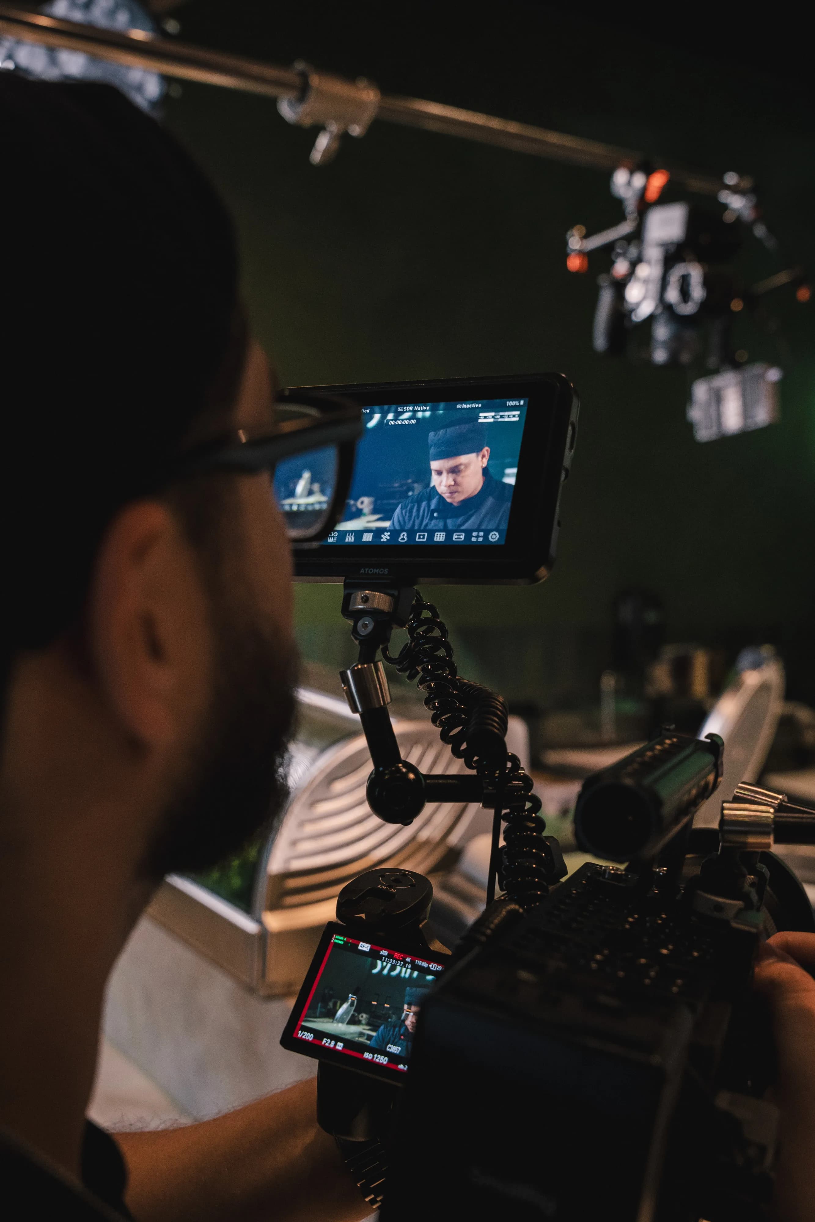 Behind the scenes — an operator reviews a Sushi Sake clip on a monitor in a dark edit setup.