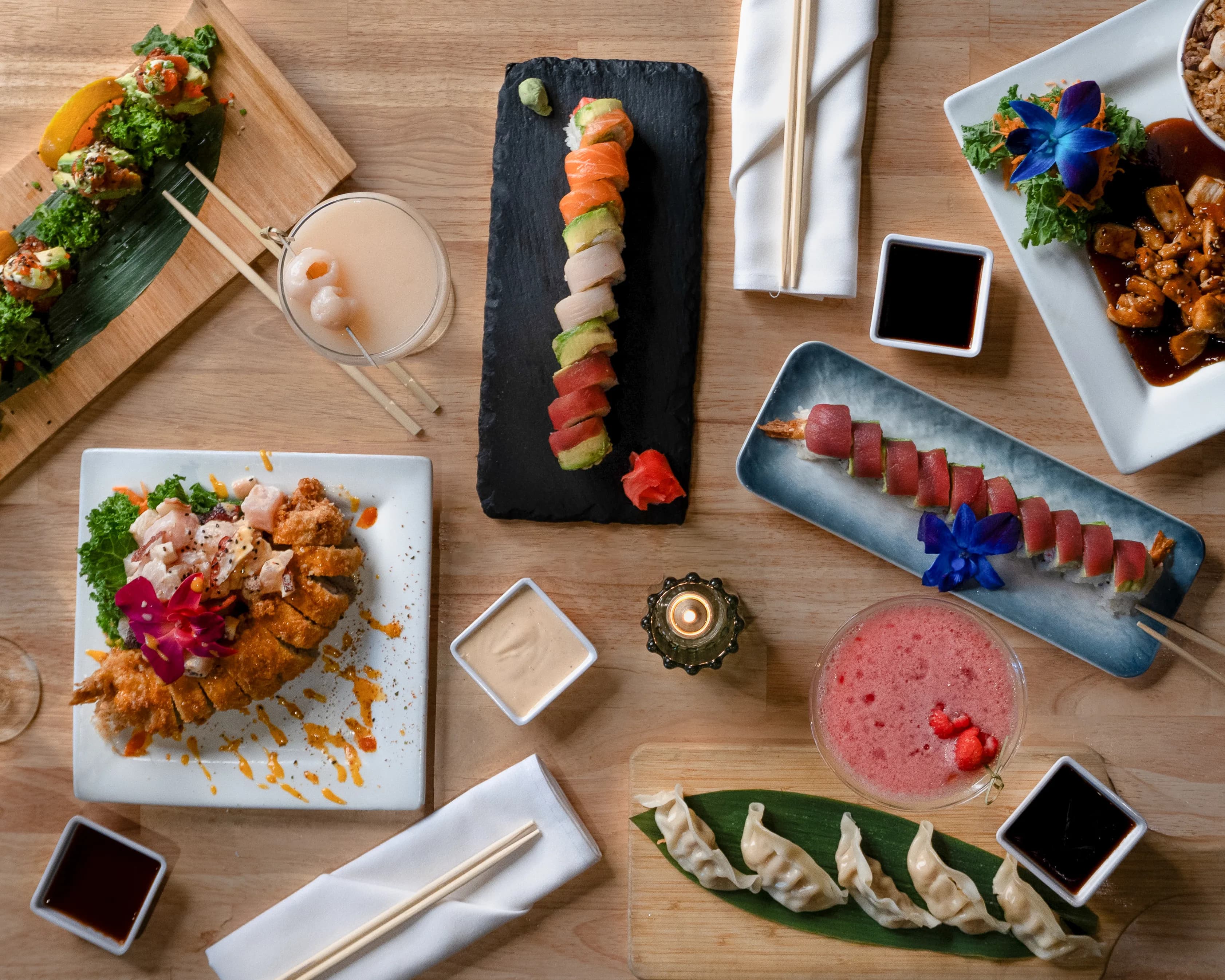 An overhead spread of Sushi Sake rolls, nigiri, and sides on a wood table.